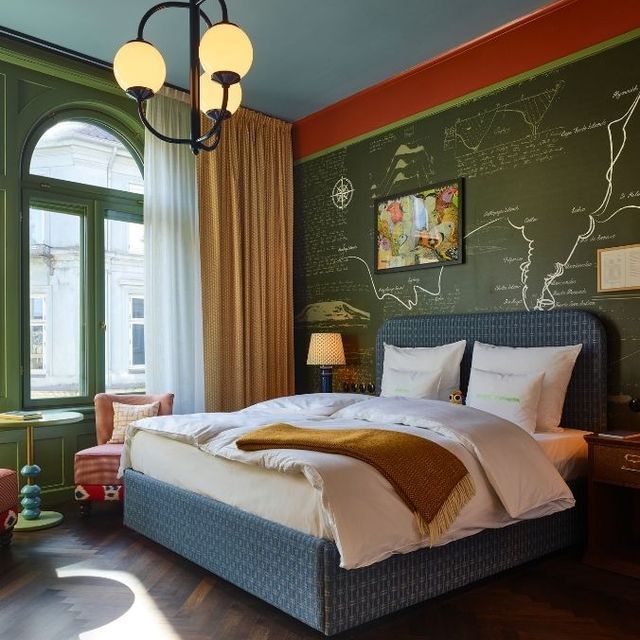 Guest room at 25hours Hotel Indre By, with a map mural behind the bed